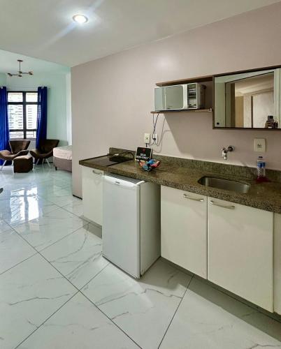 a kitchen with white cabinets and a counter top at 957 golden fortaleza frente mar in Fortaleza