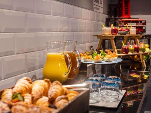 a buffet line with pastries and drinks and other foods at Novotel London Tower Bridge in London