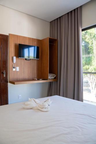 a hotel room with a bed with a towel on it at Norte Hotel in Taiobeiras