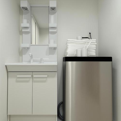 a white bathroom with a sink and a mirror at TOEI BUSSAN Building20 in Osaka