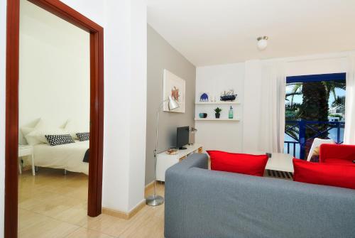 a living room with a blue couch and red pillows at Apartment La Raspa Sea Views 2 Bedrooms By PVL in Arrecife