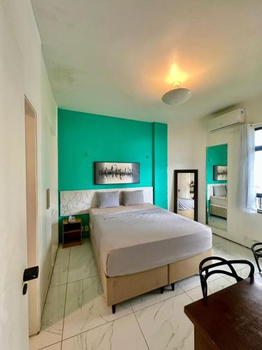 a bedroom with a large bed with a green wall at 957 golden fortaleza frente mar in Fortaleza