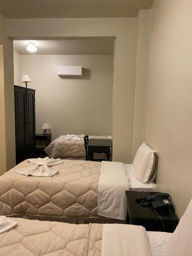 a hotel room with two beds and a mirror at Hotel Ponta Grossa São Marcos in Ponta Grossa