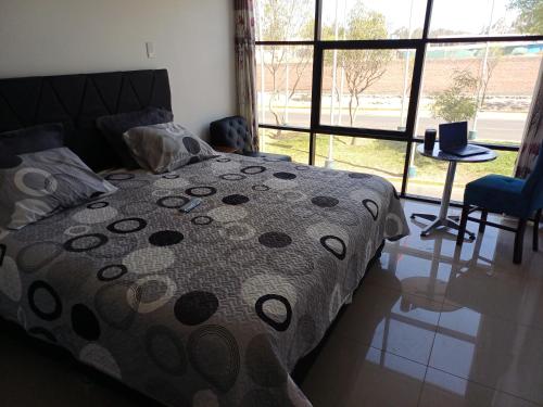 a bedroom with a bed and a large window at Hospedaje Residencial Aeropuerto in Zamacola