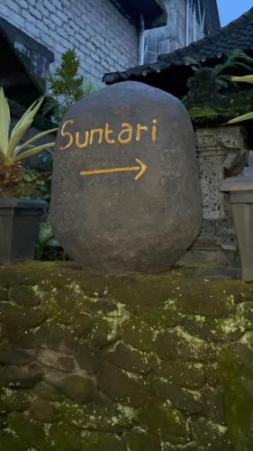 a sign that says sunort written on a rock at Suntari Homestay in Ubud
