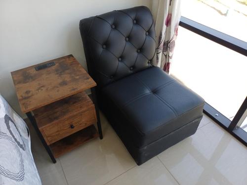 a black chair sitting next to a wooden table at Hospedaje Residencial Aeropuerto in Zamacola