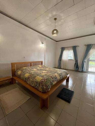 una camera da letto con un letto in una stanza di Villa des princes - Bana centre ville - Sécurisé a Bana