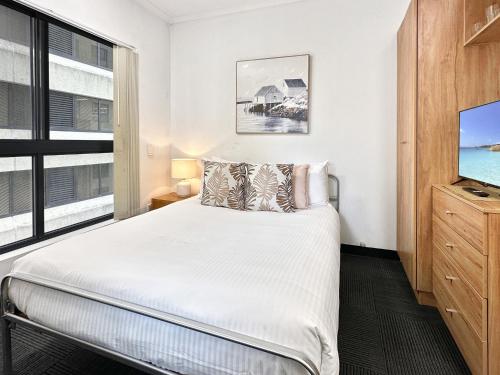 Un dormitorio con una cama y una ventana grande. en Brisbane Apt Near Dining Shops and River Walks, en Brisbane