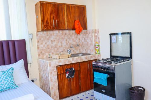 Una pequeña cocina con fregadero y estufa. en Little escalade, en Mombasa
