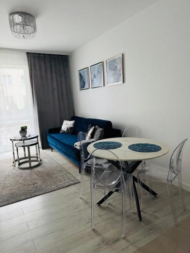a living room with two tables and a blue couch at LUX Apartament in Suwałki