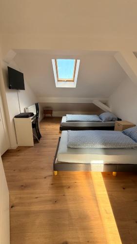 a attic room with two beds and a window at Übernachtung by Tag in Kassel