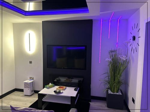 a room with a purple wall with a table and flowers at TGHA Luxury Apartments in Athlone in Athlone