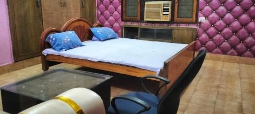 a bedroom with a bed and a chair and a table at Indrashan Marriage Garden in Muzaffarpur