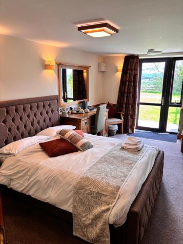 a bedroom with a large bed with a large window at Fernhill Hotel in Rochdale