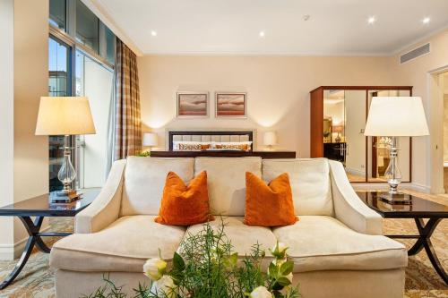 a living room with a couch with two orange pillows at Taj Hotel 305 by Host Agents in Cape Town