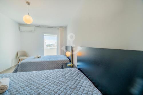 a bedroom with two beds and a window at Novo T1 com piscina - Descobrir O Mar 5 in Armação de Pêra