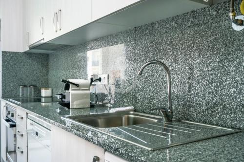 a kitchen with a sink and a counter top at Novo T1 com piscina - Descobrir O Mar 5 in Armação de Pêra