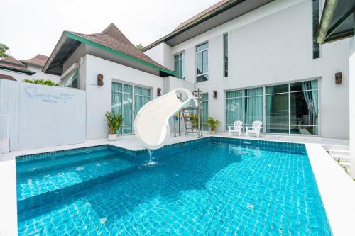 a swimming pool with a slide in front of a house at Sorrento Pool Villa Naga Jomtien Pattaya in Na Jomtien