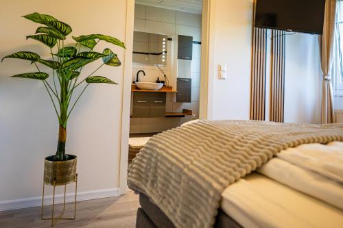 a bedroom with a bed and a potted plant at EHM Elegantes Design Apartment zwischen Linz&Wels in Pucking