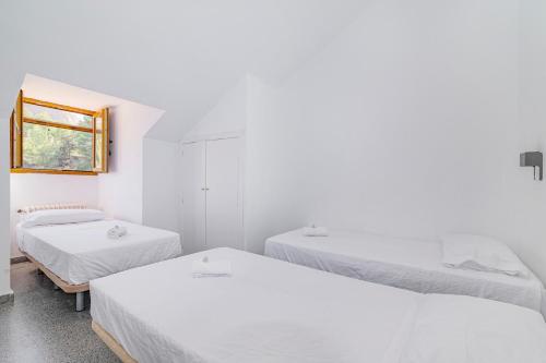a room with three beds and a window at Casa de las Nieves in Granada