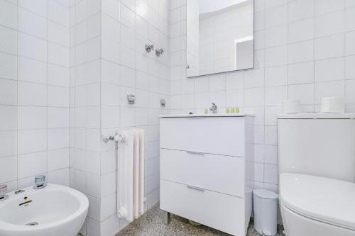 a white bathroom with a sink and a toilet at Casa de las Nieves in Granada