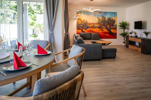 a living room with a dining table with red napkins on it at EHM Elegantes Design Apartment zwischen Linz&Wels in Pucking