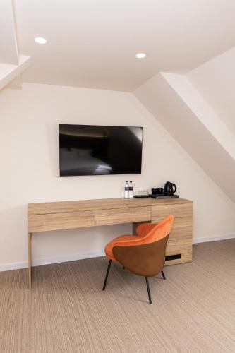 a room with a desk with a tv and a chair at Pava De Luxe in Berehove
