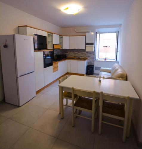 a small kitchen with a table and a refrigerator at La Dimora del Porto in Civitavecchia