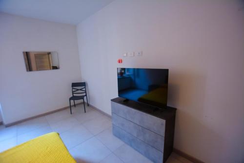 a living room with a tv and a chair at La Dimora del Porto in Civitavecchia