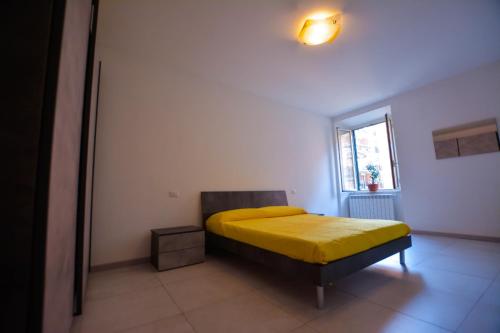 a bedroom with a bed with a yellow blanket at La Dimora del Porto in Civitavecchia