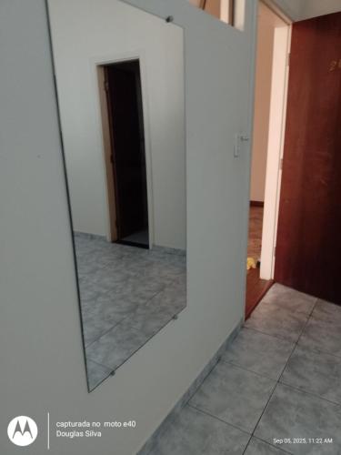 a mirror on a wall in a room at Hotel Vitoria in Varginha