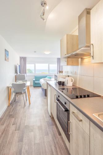 a kitchen with a counter and a living room at North Devon Resort in Ilfracombe