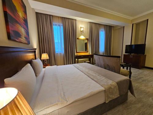 a hotel room with a large bed and a television at Crown Suites in Baku