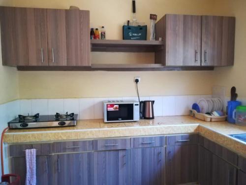Una cocina con gabinetes de madera y microondas. en Luxury 3 Bedroom Home Mtwapa, en Mtwapa