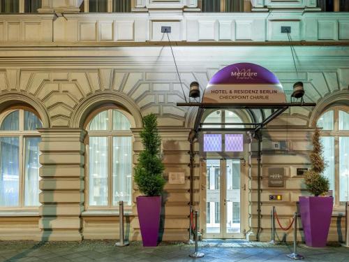 a building with two potted plants in front of it at Mercure Hotel & Residenz Berlin Checkpoint Charlie in Berlin