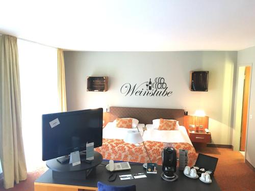 a hotel room with a bed and a desk with a computer at Mercure Hotel & Residenz Berlin Checkpoint Charlie in Berlin