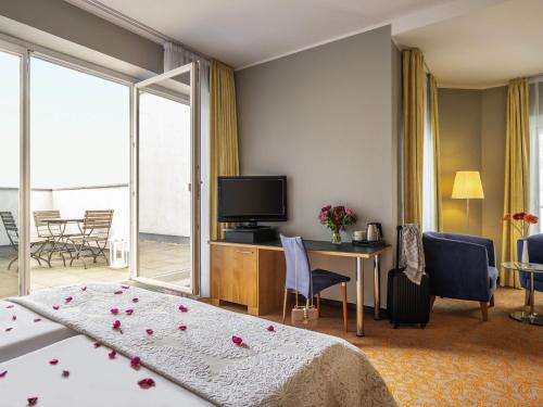 a hotel room with a bed and a television at Mercure Hotel & Residenz Berlin Checkpoint Charlie in Berlin