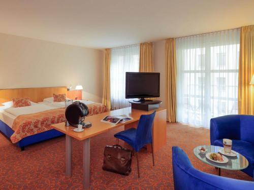 a hotel room with a bed and a television at Mercure Hotel & Residenz Berlin Checkpoint Charlie in Berlin