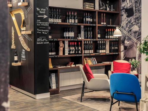 a room with two chairs and a shelf of wine bottles at Mercure Hotel & Residenz Berlin Checkpoint Charlie in Berlin