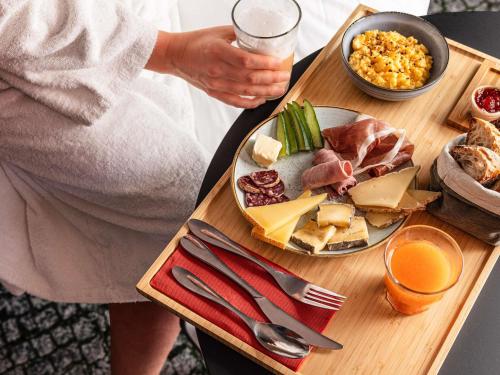 a person sitting at a table with a plate of food at Mercure Hotel & Residenz Berlin Checkpoint Charlie in Berlin