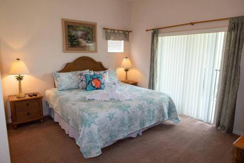 una camera da letto con un letto, due lampade e una finestra di Disney Area Vacation Kissimmee a Kissimmee