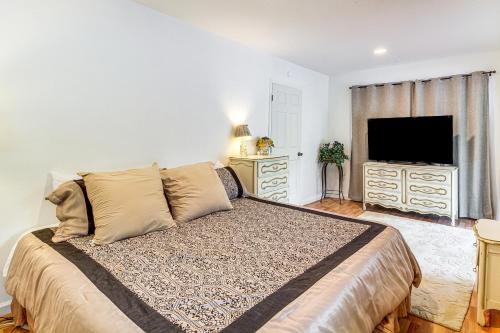 a bedroom with a large bed and a flat screen tv at 2 Mi to Downtown Coos Bay Home with Deck, Fire Pits in Coos Bay