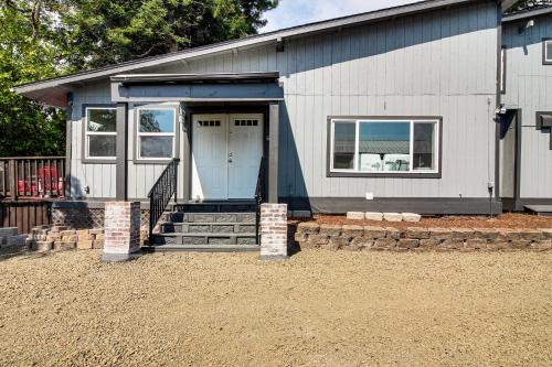 a small house with a blue door and stairs at 2 Mi to Downtown Coos Bay Home with Deck, Fire Pits in Coos Bay