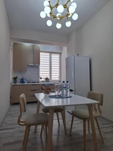 a kitchen with a table and chairs and a refrigerator at Стильная студия в центре с кухней in Bukhara