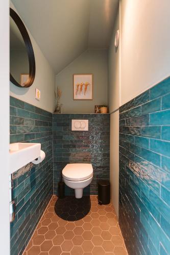 a bathroom with a toilet and a sink at Mosselbank 93 - Noordzeepark Ouddorp, with private front and back garden near the beach - not for companies in Ouddorp