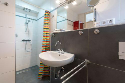 a bathroom with a sink and a shower at Veermansplaat 25 - Noordzeepark Ouddorp NOT FOR COMPANIES!! in Ouddorp