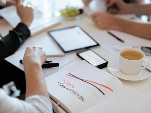 a person sitting at a table with a cup of coffee at Ibis Warszawa Ostrobramska in Warsaw