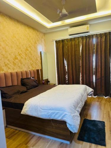 a bedroom with a large bed and a window at Anmolairbnb in Greater Noida