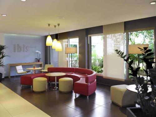 a lobby with a couch and a table and chairs at Ibis Cornella in Cornellà de Llobregat