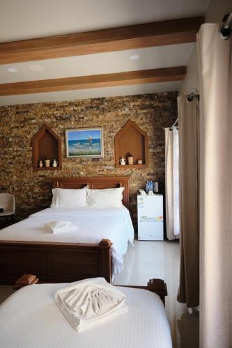 a bedroom with two beds and a brick wall at Durrat Nizwa Inn in Nizwa